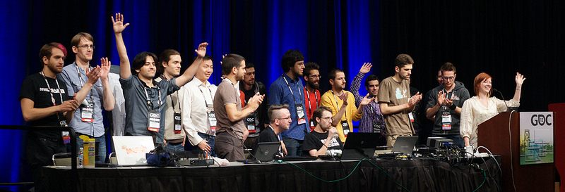 The full 2012 Experimental Gameplay Workshop line-up on stage at GDC, waving to the audience